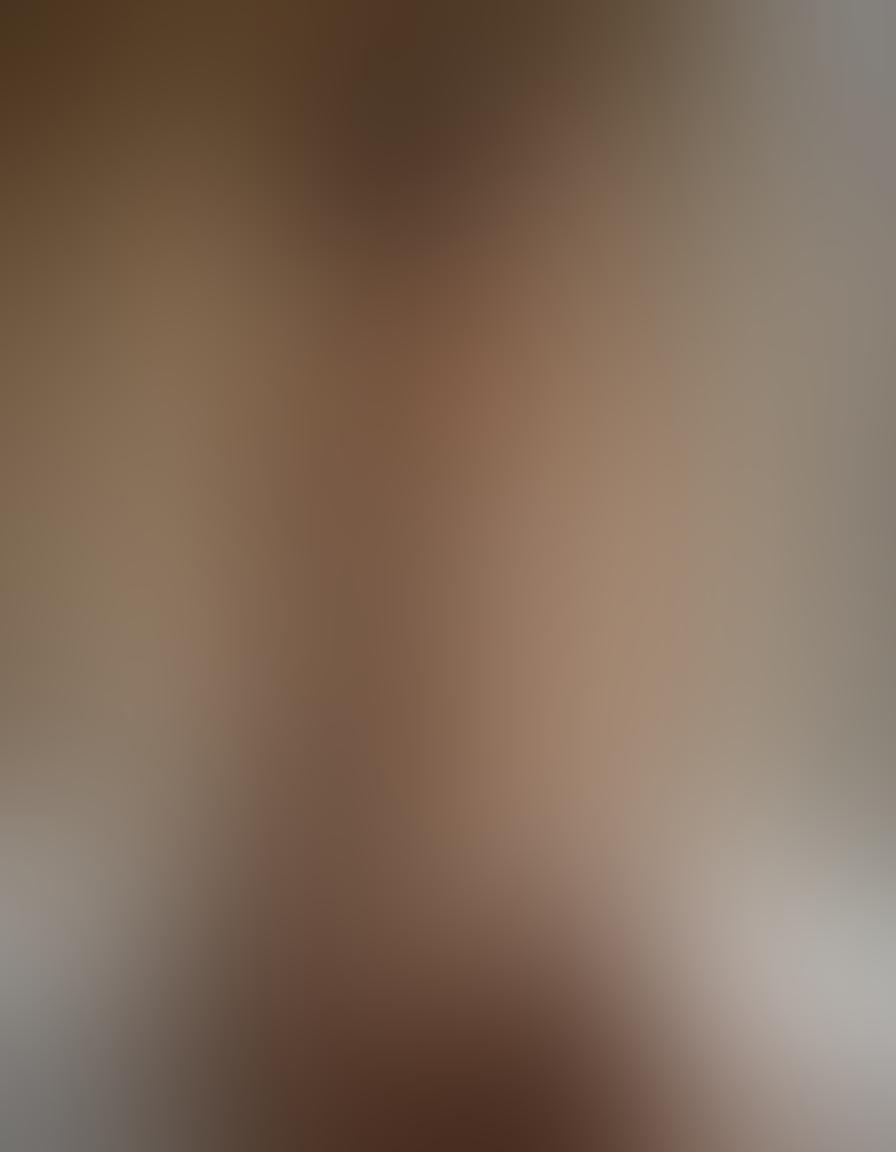 A captivating composition featuring a delicate interplay of light and shadow, showcasing a tasteful nude model draped in luxurious lace lingerie. The background should be softly blurred, filled with warm, inviting tones to evoke sensuality. Include ethereal elements like gentle flowing fabrics and subtle floral accents to enhance allure. Focus on the confidence and grace of the model, inviting viewers to appreciate the artistry of the moment. super-realistic. vibrant colors. soft focus.